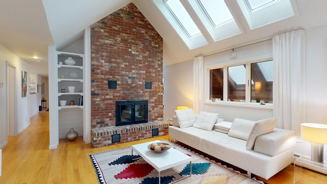 28 Meadow Ln, Brewer, ME 04412 - living room featuring vaulted ceiling, a fireplace, a skylight, light wood finished floors, and a baseboard heating unit
