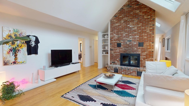 28 Meadow Ln, Brewer, ME 04412 - living area with wood finished floors, a fireplace, a skylight, high vaulted ceiling, and built in features