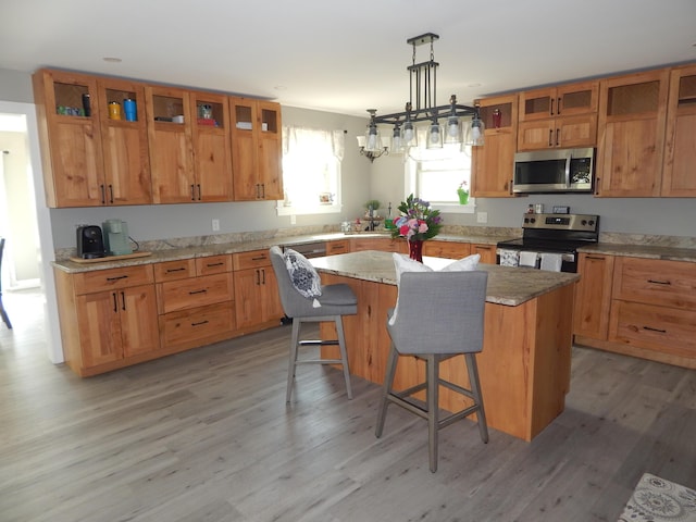 80 Pasture Ln, Brownfield, ME 04010 - kitchen with appliances with stainless steel finishes, a kitchen island, light wood-type flooring, and a kitchen breakfast bar