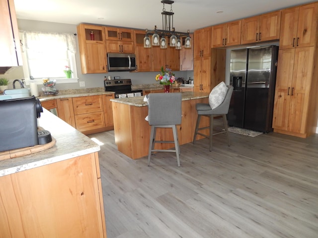 80 Pasture Ln, Brownfield, ME 04010 - kitchen featuring appliances with stainless steel finishes, a breakfast bar, light wood-type flooring, a center island, and hanging light fixtures