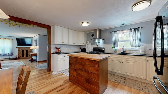 76 School St, Baldwin, ME 04024 - kitchen with black appliances, butcher block countertops, light wood-type flooring, and a sink