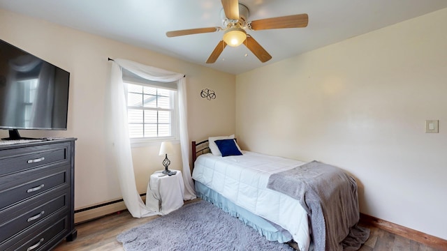 76 School St, Baldwin, ME 04024 - bedroom featuring baseboard heating, light wood-type flooring, baseboards, and a ceiling fan