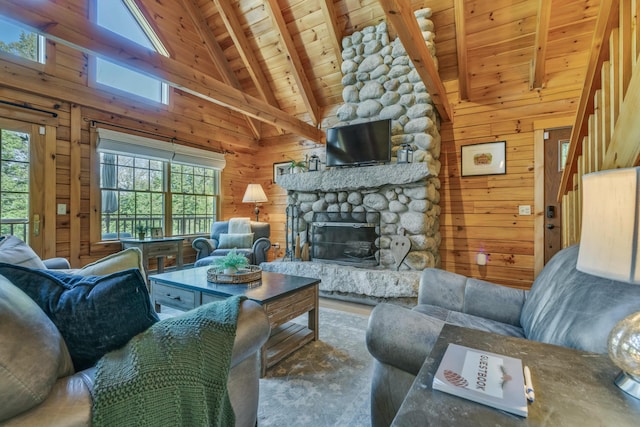 living area featuring wood ceiling, beam ceiling, wood walls, a fireplace, and high vaulted ceiling