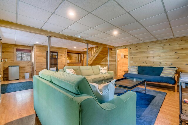 living area featuring wood walls, stairs, wood finished floors, a paneled ceiling, and recessed lighting