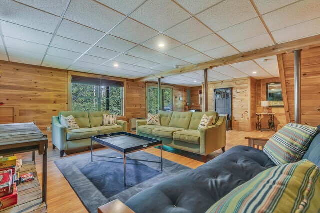 living area featuring wood walls, wood finished floors, a paneled ceiling, and recessed lighting