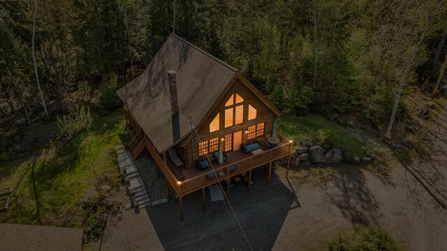 rear view of property with a forest view and a deck
