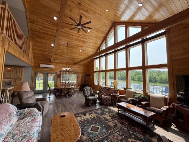 1027 Gardner Creek Rd, Wade, ME 04786 - living area featuring wooden ceiling, high vaulted ceiling, a ceiling fan, wood finished floors, and a wall mounted air conditioner