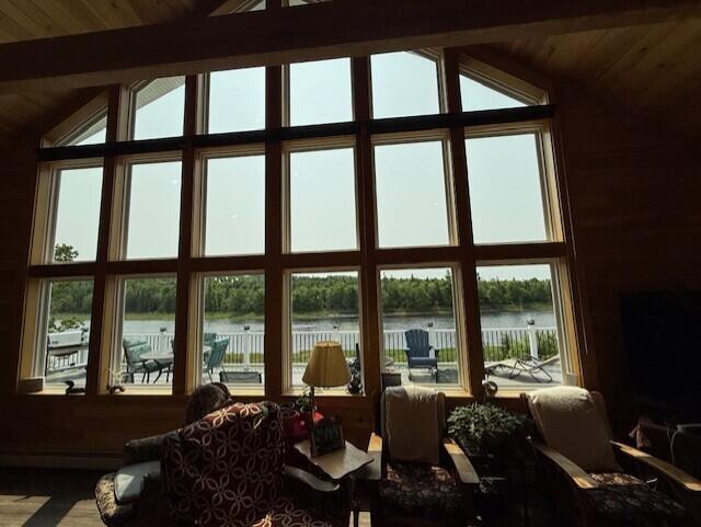 1027 Gardner Creek Rd, Wade, ME 04786 - living area with a water view, plenty of natural light, wooden ceiling, and wood finished floors