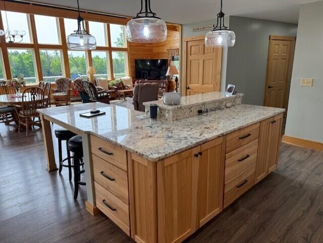 1027 Gardner Creek Rd, Wade, ME 04786 - kitchen with dark wood-style floors, a breakfast bar, and hanging light fixtures
