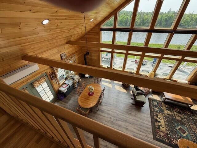 1027 Gardner Creek Rd, Wade, ME 04786 - living room with high vaulted ceiling, healthy amount of natural light, a water view, wooden walls, and wood finished floors