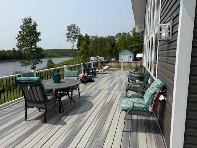1027 Gardner Creek Rd, Wade, ME 04786 - wooden terrace with a water view, outdoor dining space, and a storage shed