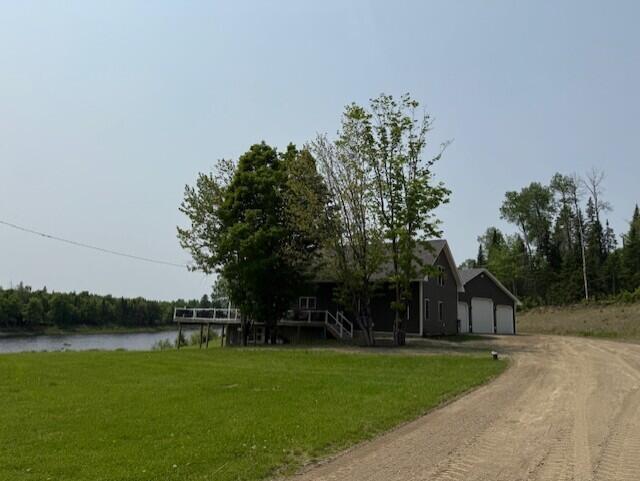 1027 Gardner Creek Rd, Wade, ME 04786 - view of front of house with driveway, a front yard, a water view, and a garage