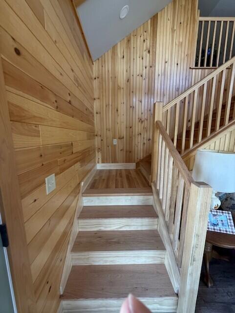 1027 Gardner Creek Rd, Wade, ME 04786 - staircase with wooden walls, hardwood / wood-style flooring, a sauna / steam room, and lofted ceiling