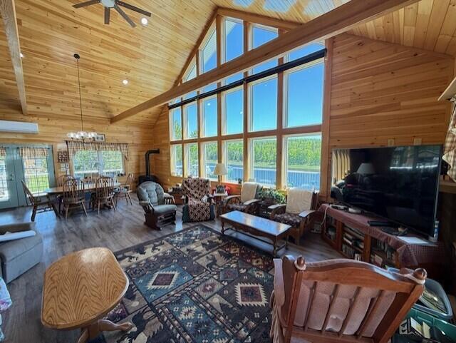 1027 Gardner Creek Rd, Wade, ME 04786 - living area with high vaulted ceiling, wooden walls, a ceiling fan, a chandelier, and wood finished floors