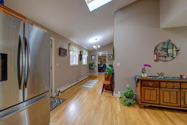74 Spear Rd, Standish, ME 04084 - foyer entrance featuring baseboard heating, light wood-style floors, a chandelier, a skylight, and vaulted ceiling