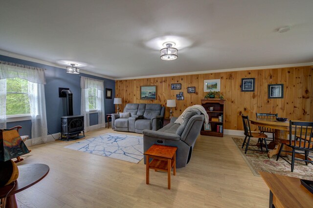 74 Spear Rd, Standish, ME 04084 - living room with a wood stove, ornamental molding, light wood-type flooring, baseboards, and wooden walls