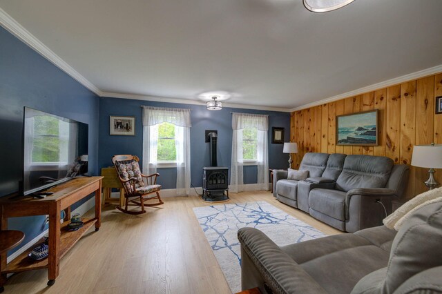74 Spear Rd, Standish, ME 04084 - living area featuring a wood stove, crown molding, light wood finished floors, baseboards, and wooden walls