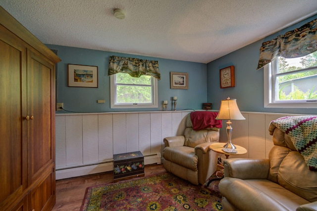 74 Spear Rd, Standish, ME 04084 - living area with a baseboard radiator, wainscoting, a textured ceiling, a baseboard heating unit, and wood finished floors