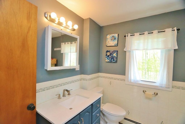 387 Nicolin Rd, Ellsworth, ME 04605 - bathroom with tile walls, toilet, vanity, a wainscoted wall, and a baseboard radiator