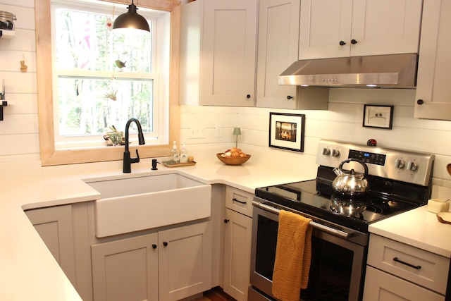 382 Riverbend Rd, Brownfield, ME 04010 - kitchen with stainless steel electric stove, under cabinet range hood, a sink, light countertops, and tasteful backsplash