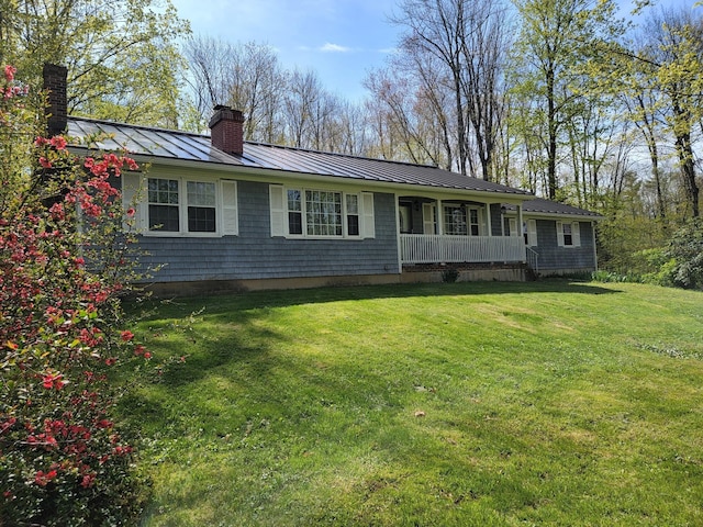 188 Boothbay Rd, Edgecomb, ME 04556 - view of front of home with a standing seam roof, a chimney, a metal roof, a front yard, and a porch