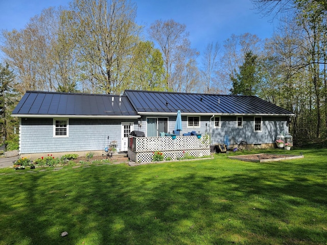 188 Boothbay Rd, Edgecomb, ME 04556 - back of house featuring a standing seam roof, a metal roof, a lawn, and a wooden deck