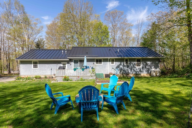 188 Boothbay Rd, Edgecomb, ME 04556 - rear view of house featuring a standing seam roof, a metal roof, a lawn, and a wooden deck