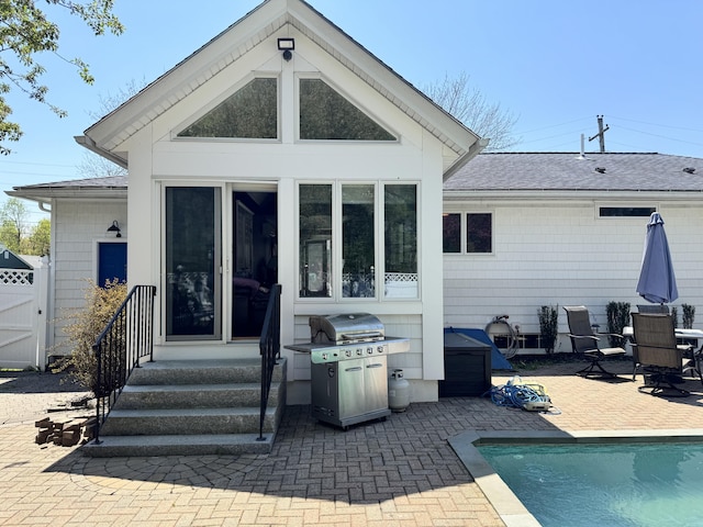 10 Goulet St, Lewiston, ME 04240 - rear view of property featuring a patio area, a shingled roof, an outdoor pool, a gate, and entry steps