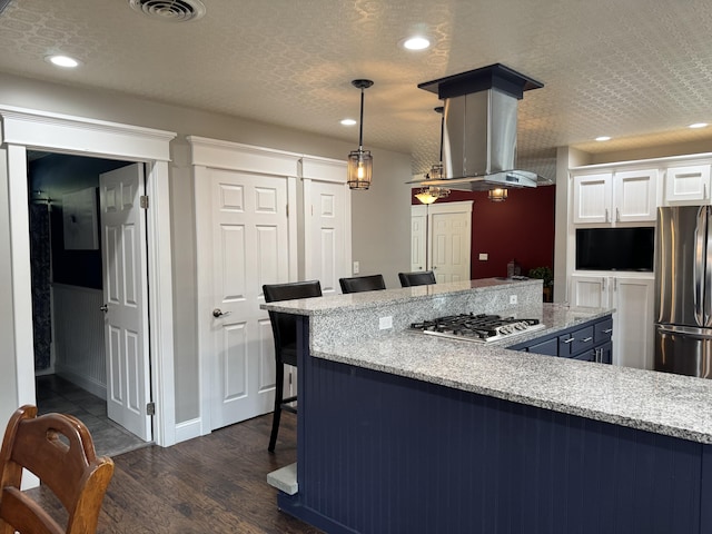 10 Goulet St, Lewiston, ME 04240 - kitchen with stainless steel appliances, a kitchen bar, white cabinets, dark wood-style floors, and hanging light fixtures