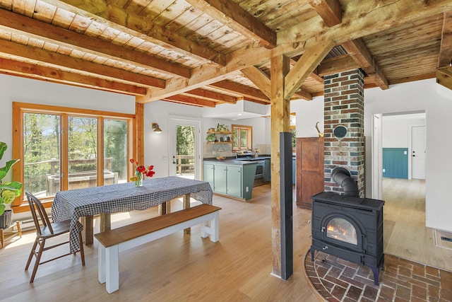 121 Heal Rd, Lincolnville, ME 04849 - dining area featuring a wood stove, wood ceiling, beamed ceiling, and light wood finished floors