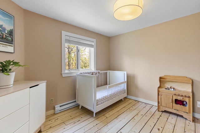 121 Heal Rd, Lincolnville, ME 04849 - bedroom featuring a baseboard heating unit, light wood-style floors, and baseboards