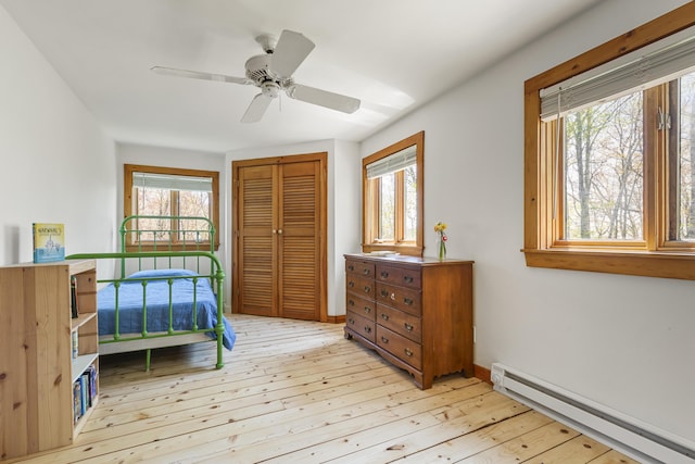 121 Heal Rd, Lincolnville, ME 04849 - bedroom with a baseboard radiator, light wood finished floors, a closet, and ceiling fan