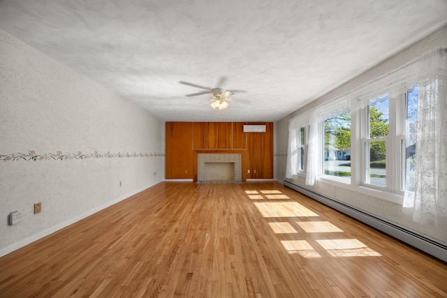 164 Dewitt Ave, Bangor, ME 04401 - unfurnished living room with baseboard heating, light wood finished floors, a brick fireplace, ceiling fan, and baseboards