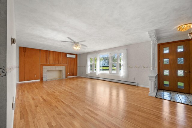 164 Dewitt Ave, Bangor, ME 04401 - unfurnished living room with a baseboard heating unit, decorative columns, ceiling fan, wood finished floors, and baseboards