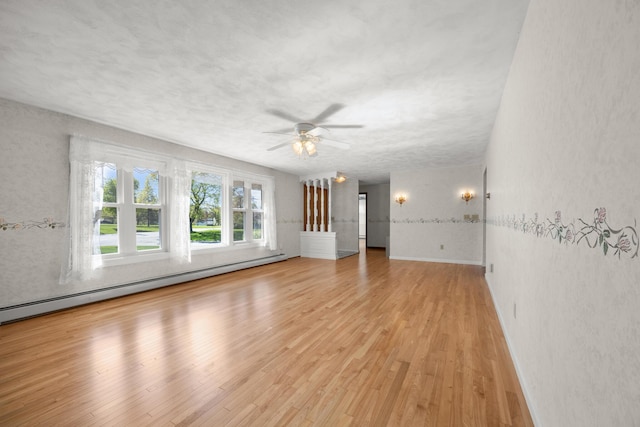 164 Dewitt Ave, Bangor, ME 04401 - unfurnished living room featuring baseboard heating, ceiling fan, light wood-style floors, and baseboards