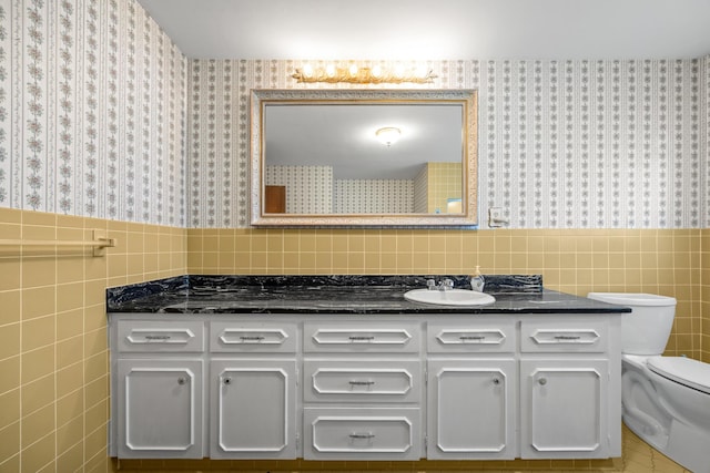 164 Dewitt Ave, Bangor, ME 04401 - bathroom featuring wallpapered walls, tile walls, vanity, toilet, and wainscoting