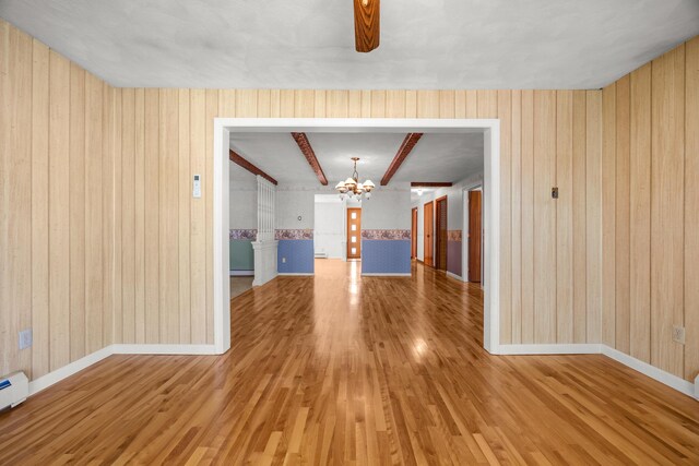 164 Dewitt Ave, Bangor, ME 04401 - unfurnished dining area featuring a chandelier, wood finished floors, wooden walls, baseboards, and baseboard heating