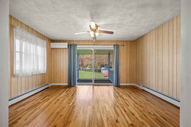 164 Dewitt Ave, Bangor, ME 04401 - empty room featuring a baseboard heating unit, wood finished floors, a ceiling fan, baseboards, and wooden walls