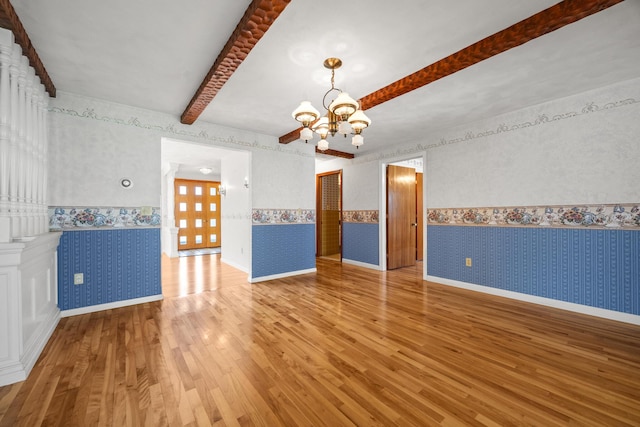 164 Dewitt Ave, Bangor, ME 04401 - spare room with wallpapered walls, a chandelier, wood finished floors, beamed ceiling, and a wainscoted wall