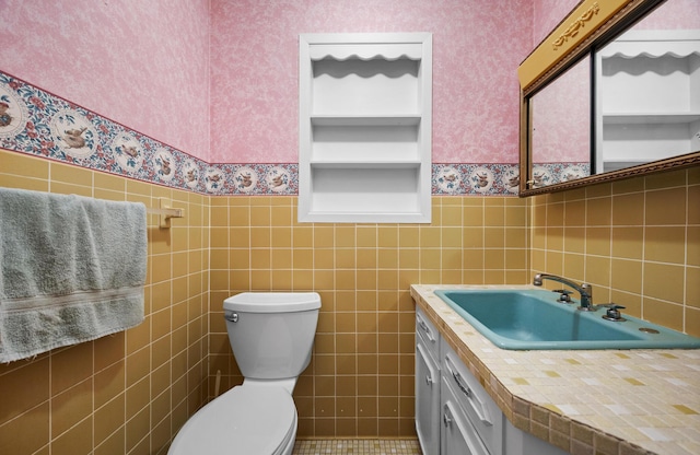 164 Dewitt Ave, Bangor, ME 04401 - half bath with wallpapered walls, a wainscoted wall, toilet, tile walls, and vanity