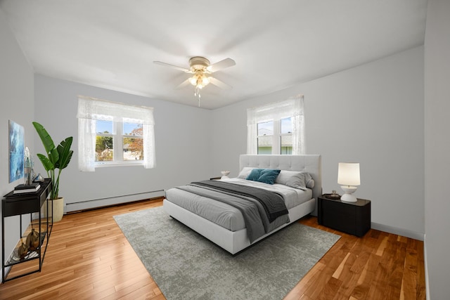 164 Dewitt Ave, Bangor, ME 04401 - bedroom featuring a baseboard radiator, multiple windows, light wood finished floors, and ceiling fan
