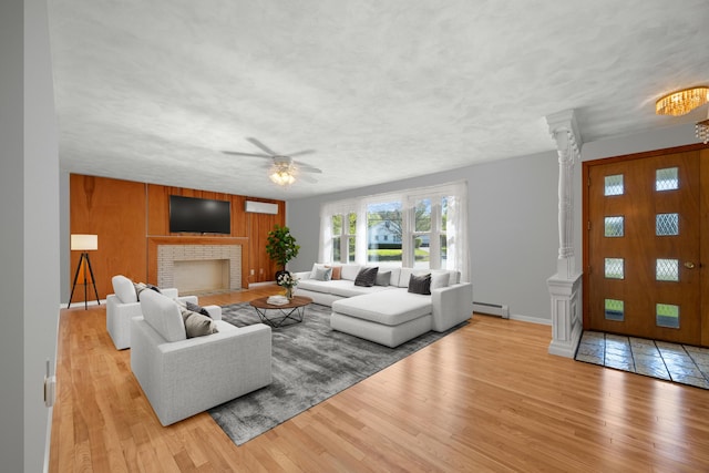 164 Dewitt Ave, Bangor, ME 04401 - living room featuring baseboard heating, ornate columns, wood finished floors, baseboards, and a ceiling fan