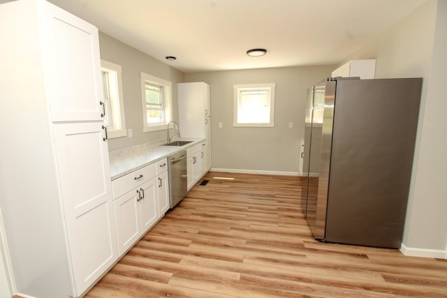 342 Spring Bridge Rd, Greenbush, ME 04418 - kitchen featuring stainless steel appliances, a sink, light wood-type flooring, white cabinetry, and baseboards