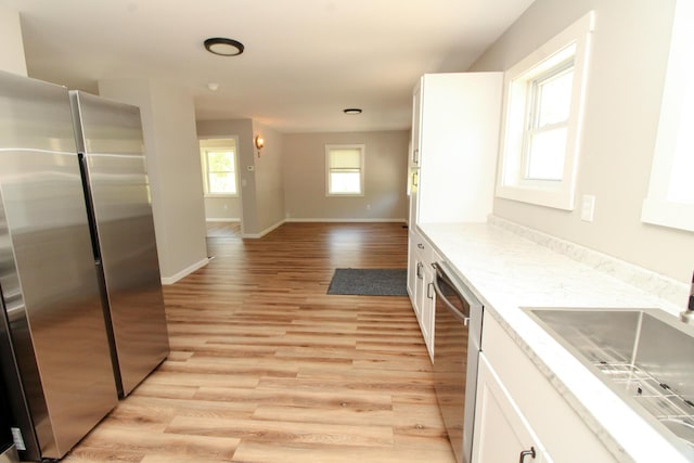 342 Spring Bridge Rd, Greenbush, ME 04418 - kitchen featuring appliances with stainless steel finishes, a sink, white cabinets, light wood finished floors, and baseboards