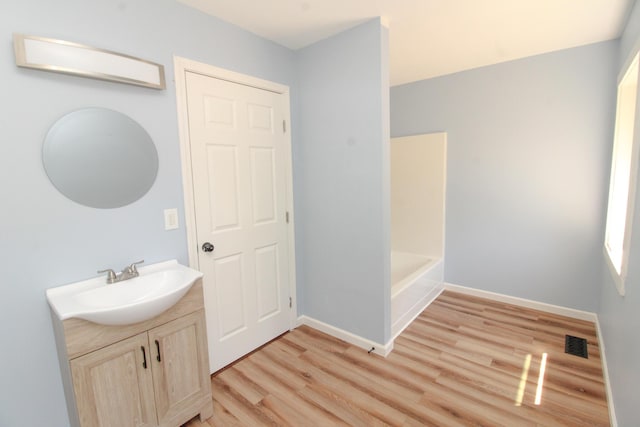 342 Spring Bridge Rd, Greenbush, ME 04418 - bathroom featuring wood finished floors, vanity, baseboards, and a tub to relax in