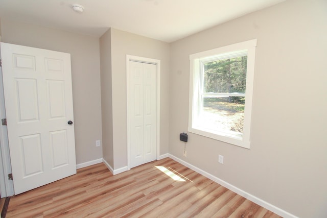 342 Spring Bridge Rd, Greenbush, ME 04418 - unfurnished bedroom featuring light wood-style flooring, a closet, and baseboards