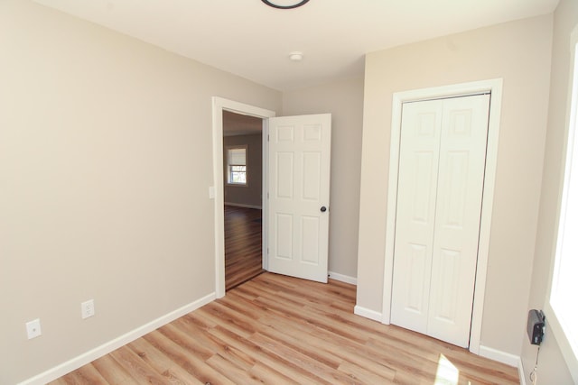 342 Spring Bridge Rd, Greenbush, ME 04418 - unfurnished bedroom featuring baseboards, light wood finished floors, and a closet