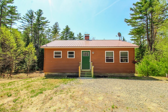 342 Spring Bridge Rd, Greenbush, ME 04418 - rear view of house with entry steps, a chimney, metal roof, and faux log siding