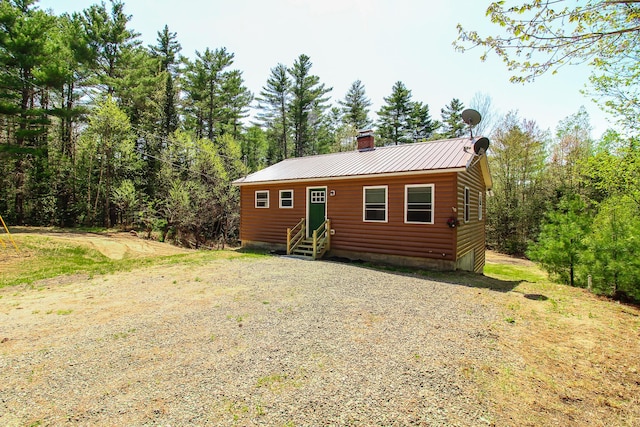 342 Spring Bridge Rd, Greenbush, ME 04418 - view of front of home with entry steps, faux log siding, metal roof, and a chimney