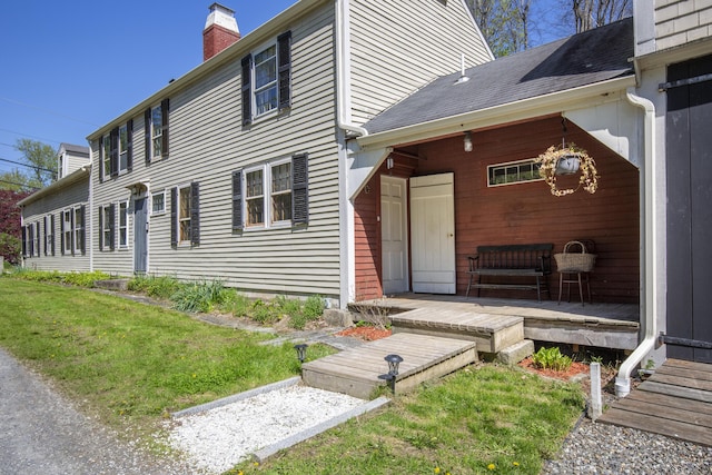42 Winthrop St, Hallowell, ME 04347 - view of side of property with a chimney, a lawn, a deck, and roof with shingles